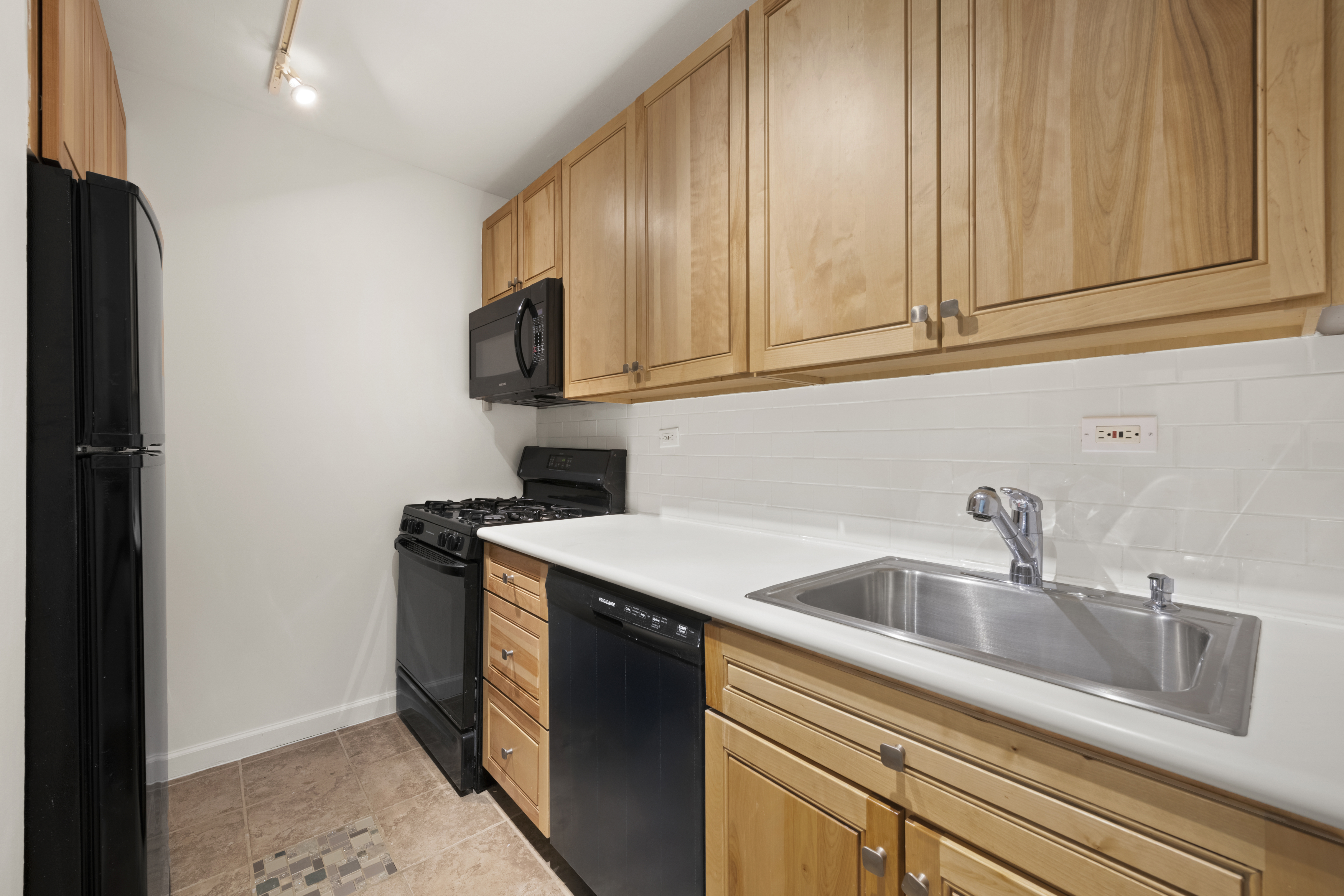 170 West End Avenue, Unit 15L Manhattan, NY 10023 - Photo 4 of 11 a kitchen with stainless steel appliances granite countertop a sink stove and refrigerator