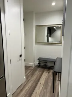 a view of a hallway with wooden floor and furniture