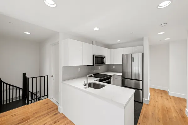 a kitchen with stainless steel appliances a refrigerator and a stove top oven
