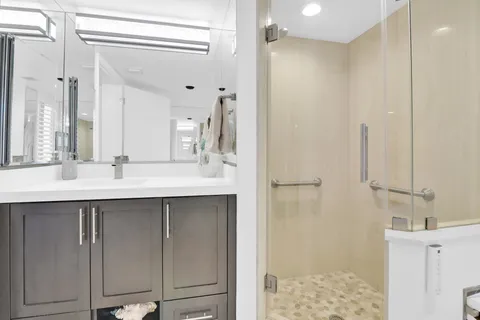 a bathroom with a double vanity sink a mirror and shower