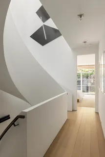 a spacious bedroom with a bed and wooden floor