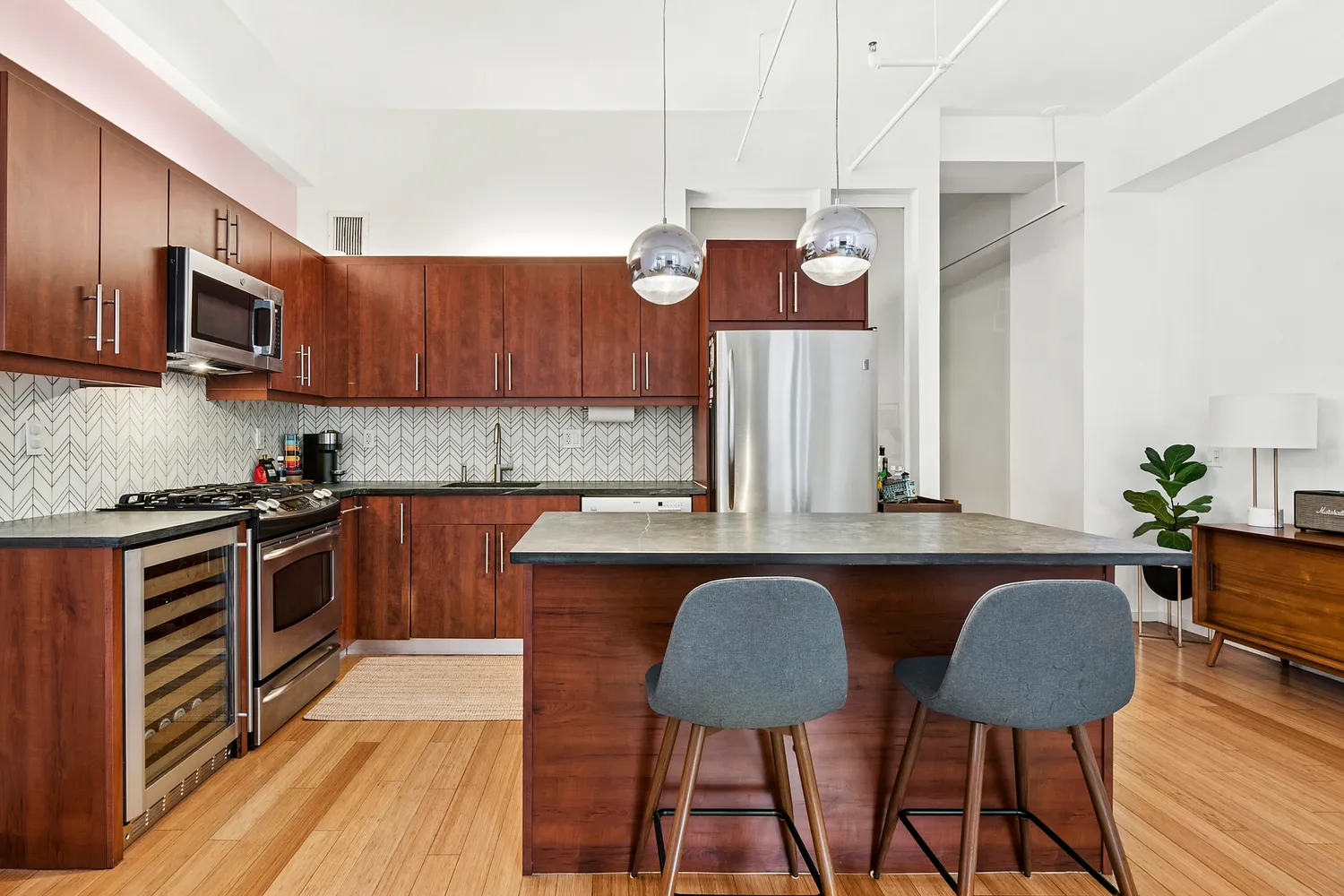 a kitchen with stainless steel appliances granite countertop a kitchen island hardwood floor sink stove dining table and chairs