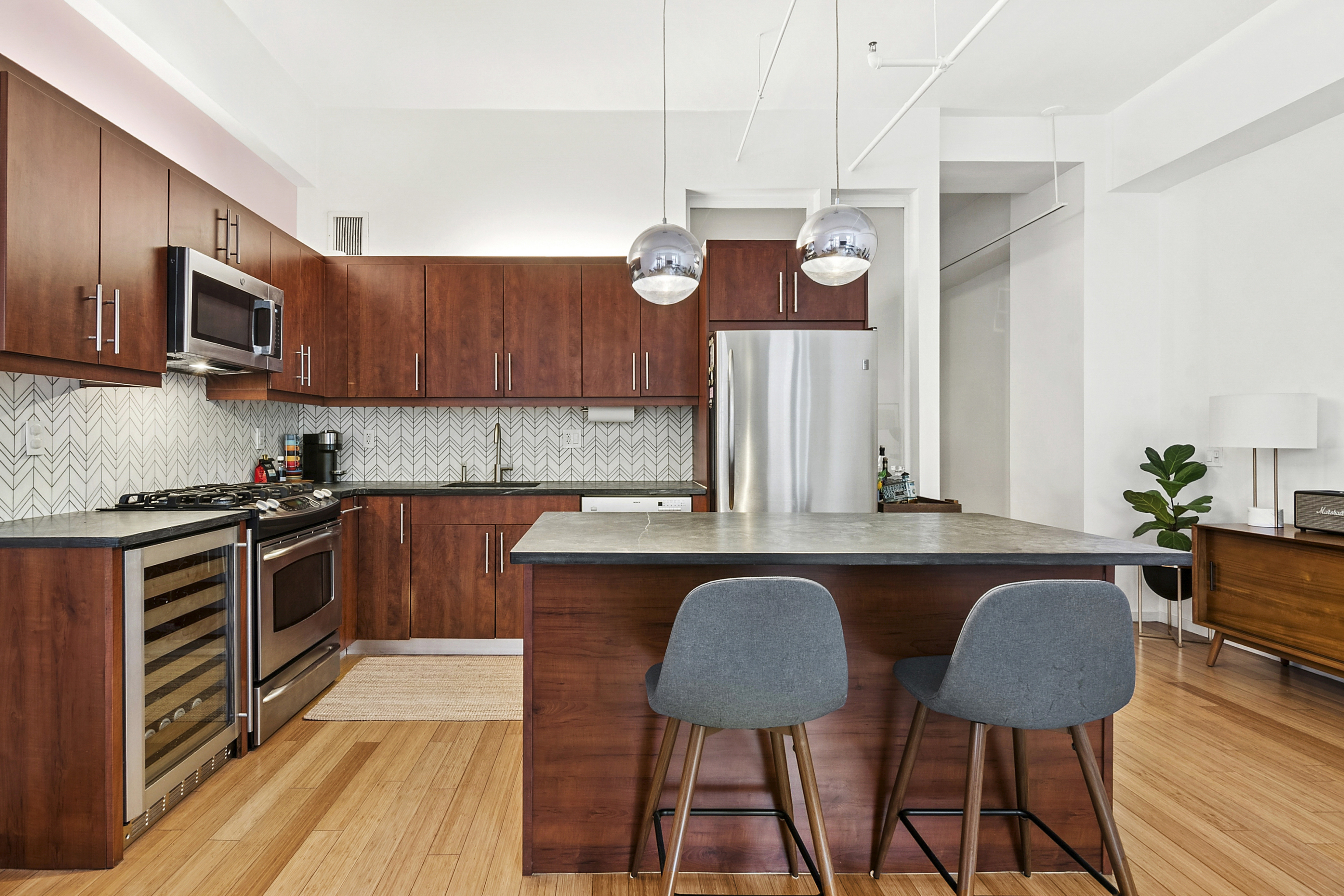 a kitchen with stainless steel appliances granite countertop a kitchen island hardwood floor sink stove dining table and chairs