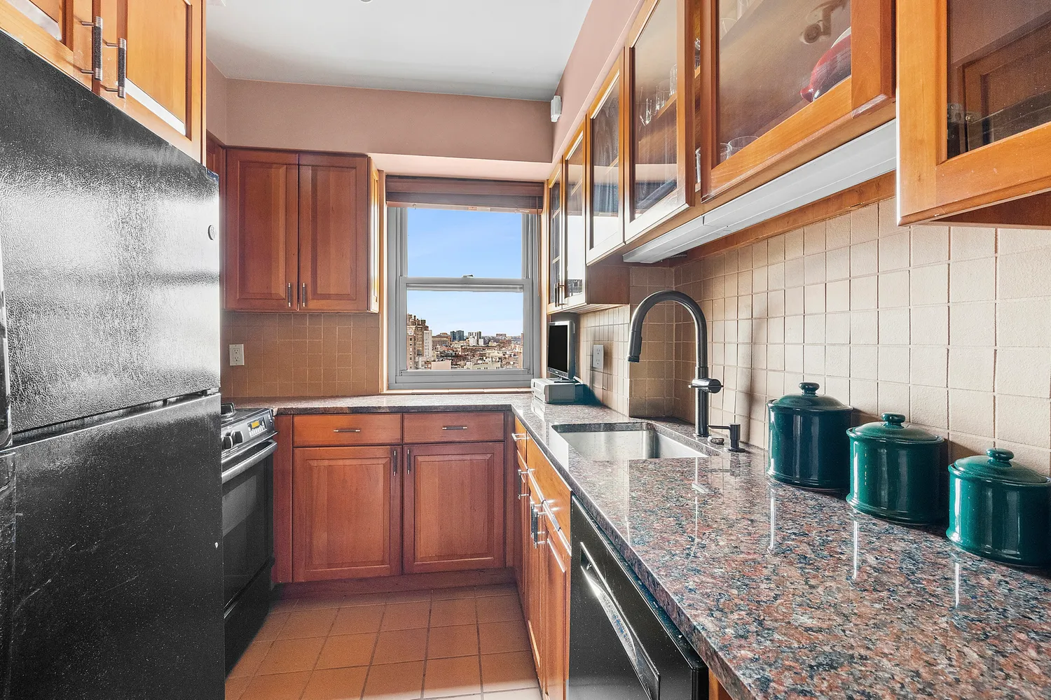 a kitchen with stainless steel appliances granite countertop a sink a stove and a wooden cabinets