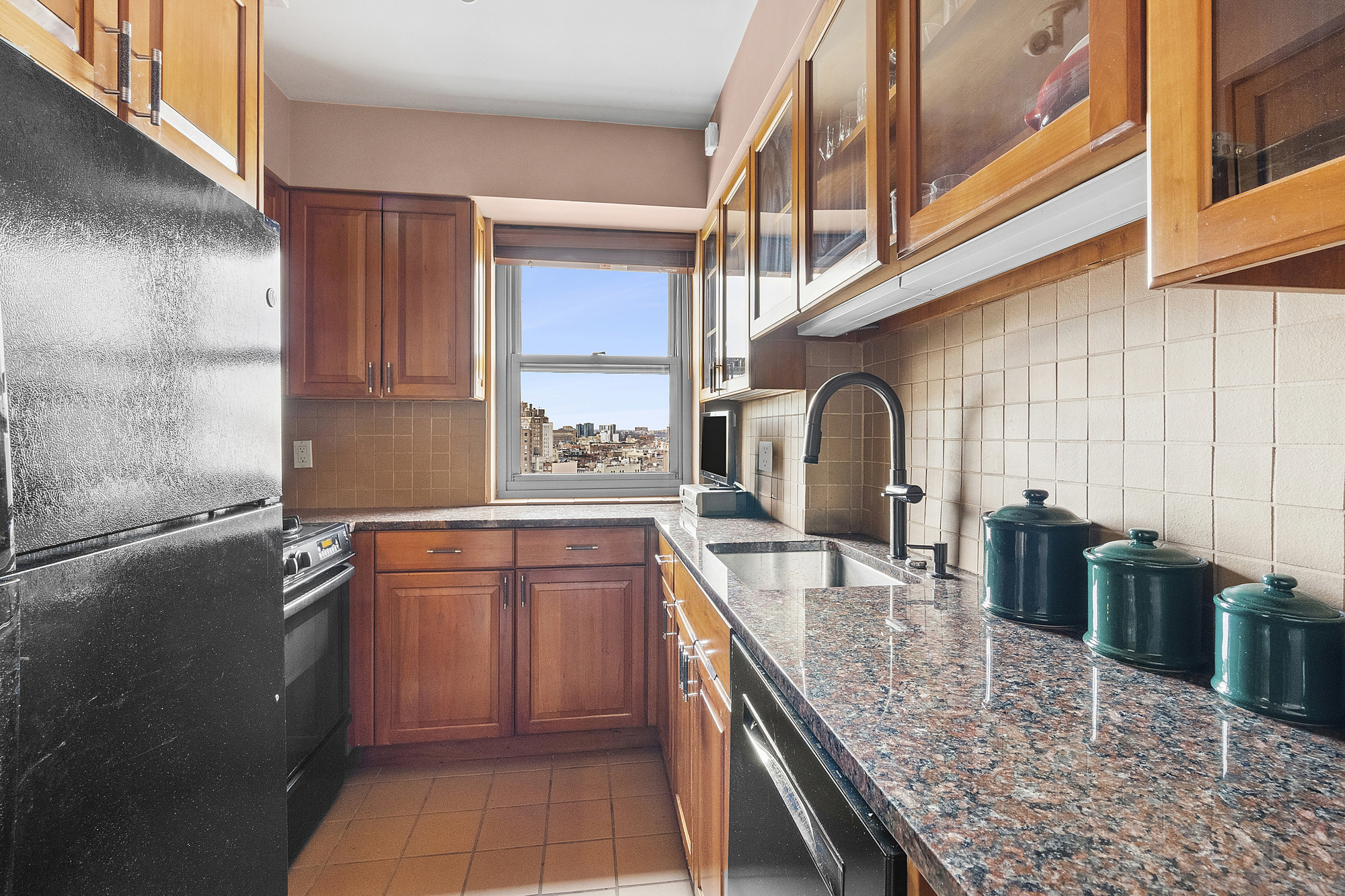 2 5th Avenue, Unit 15U Manhattan, NY 10011 - Photo 5 of 13 a kitchen with stainless steel appliances granite countertop a sink a stove and a wooden cabinets