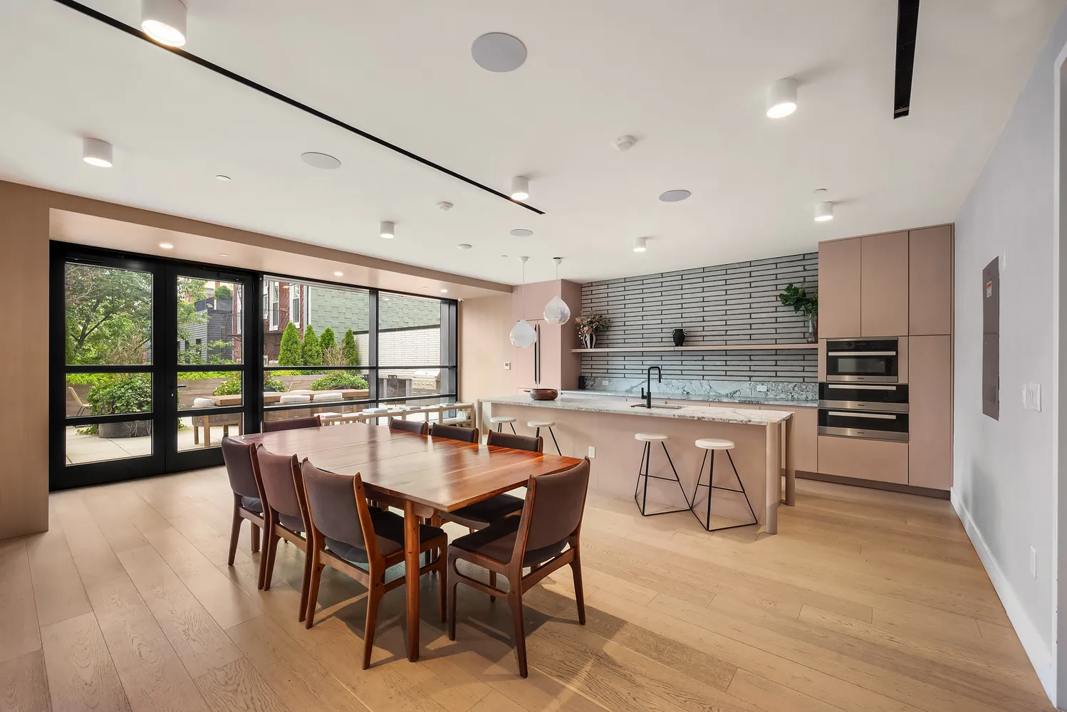 a dining room with stainless steel appliances granite countertop a sink a stove a dining table and chairs
