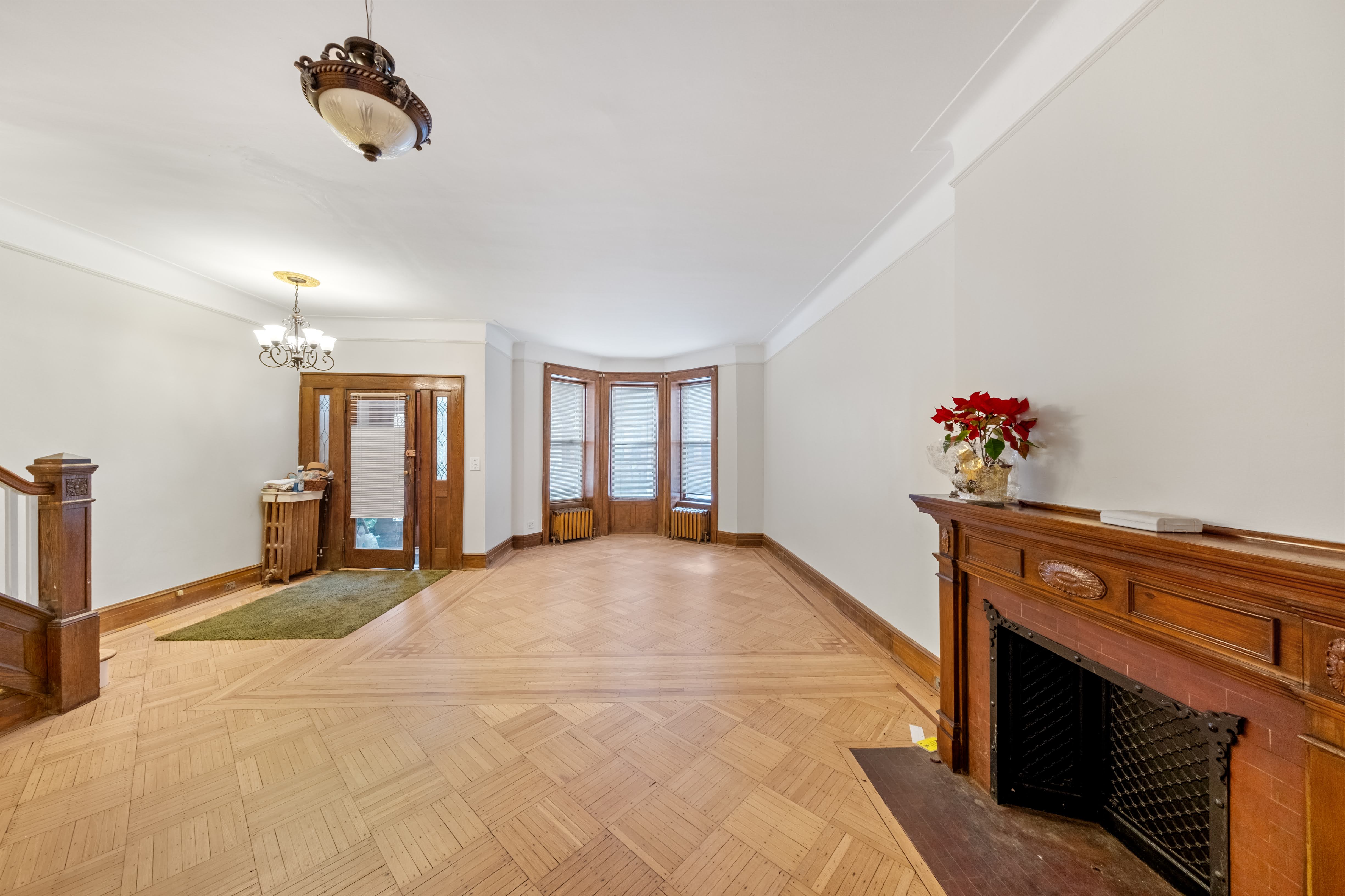 196 Maple Street Brooklyn, NY 11225 - Photo 2 of 31 a spacious bedroom with a bed and a chandelier