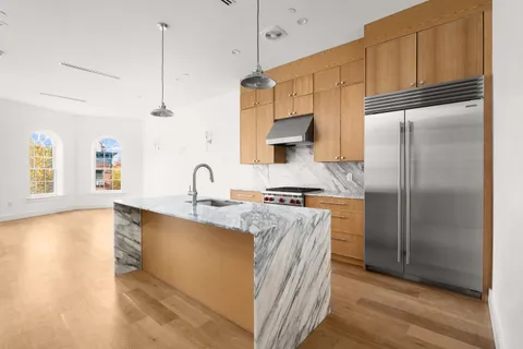 a kitchen with stainless steel appliances granite countertop a refrigerator a sink and a stove