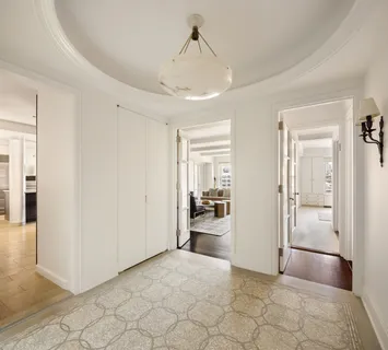 a view of a hallway with a livingroom and a bathroom