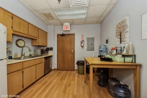 a kitchen with stainless steel appliances granite countertop a refrigerator a stove and white cabinets with wooden floor