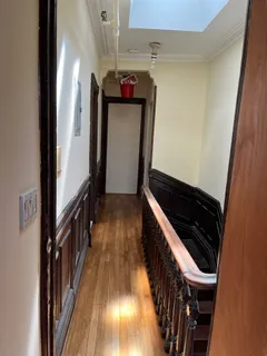 a view of a hallway with wooden floor and staircase