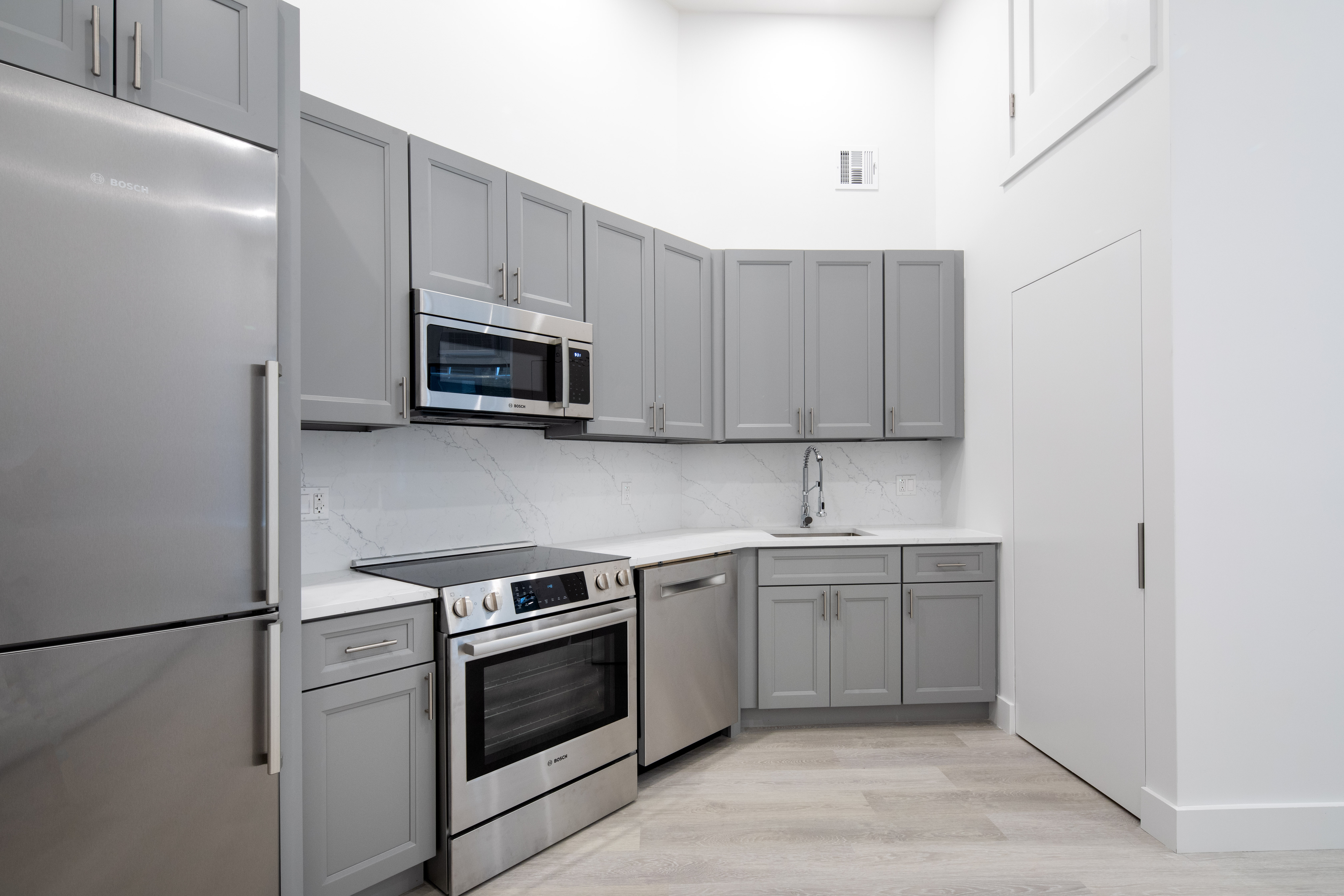 74 Leonard Street, Unit 5B Manhattan, NY 10013 - Photo 1 of 6 a kitchen with granite countertop white cabinets stainless steel appliances and a sink