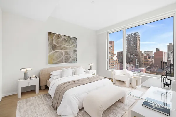 a bedroom with furniture and a large window