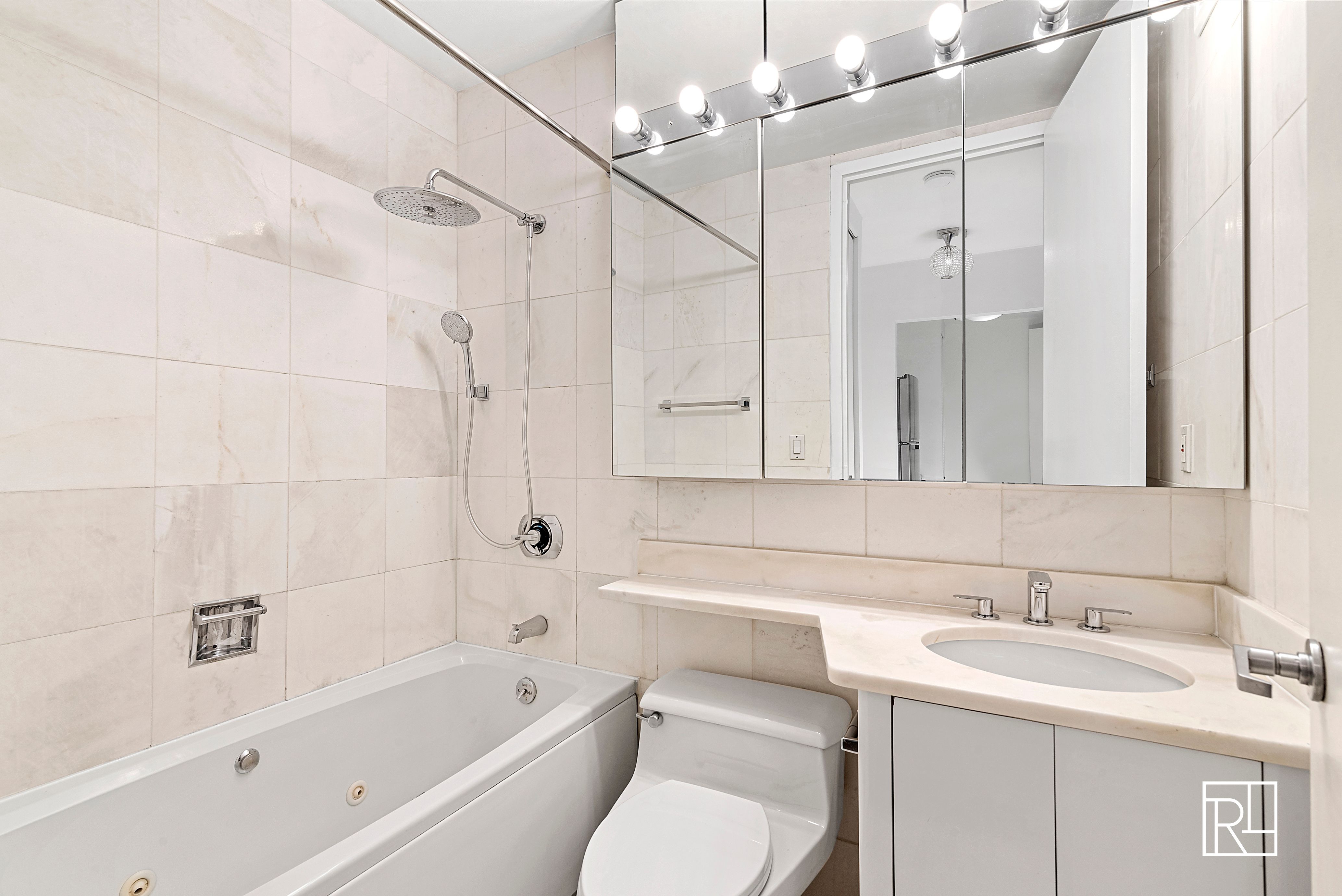 161 West 61st Street, Unit 12D Manhattan, NY 10023 - Photo 6 of 15 a bathroom with a sink toilet vanity and bathtub