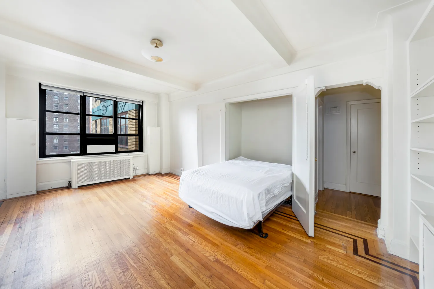 a bedroom with a bed and wooden floor