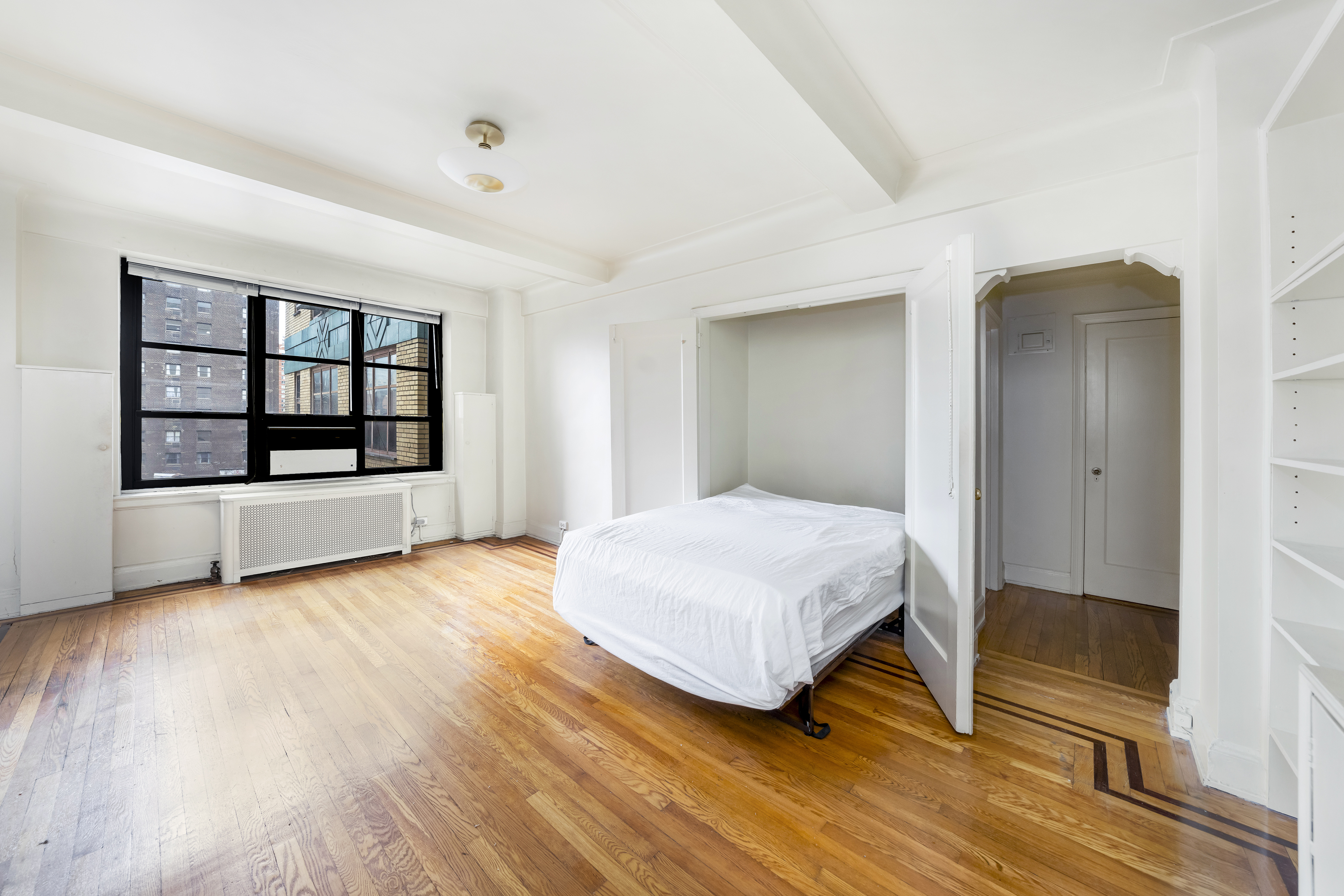 235 East 22nd Street, Unit 9M Manhattan, NY 10010 - Photo 5 of 15 a bedroom with a bed and wooden floor