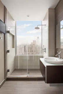 a view of a bathroom with a double vanity sink a mirror and a shower
