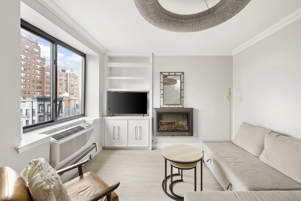 160 East 26th Street, Unit 6B Manhattan, NY 10010 - Photo 3 of 10 a living room with furniture a flat screen tv and a large window