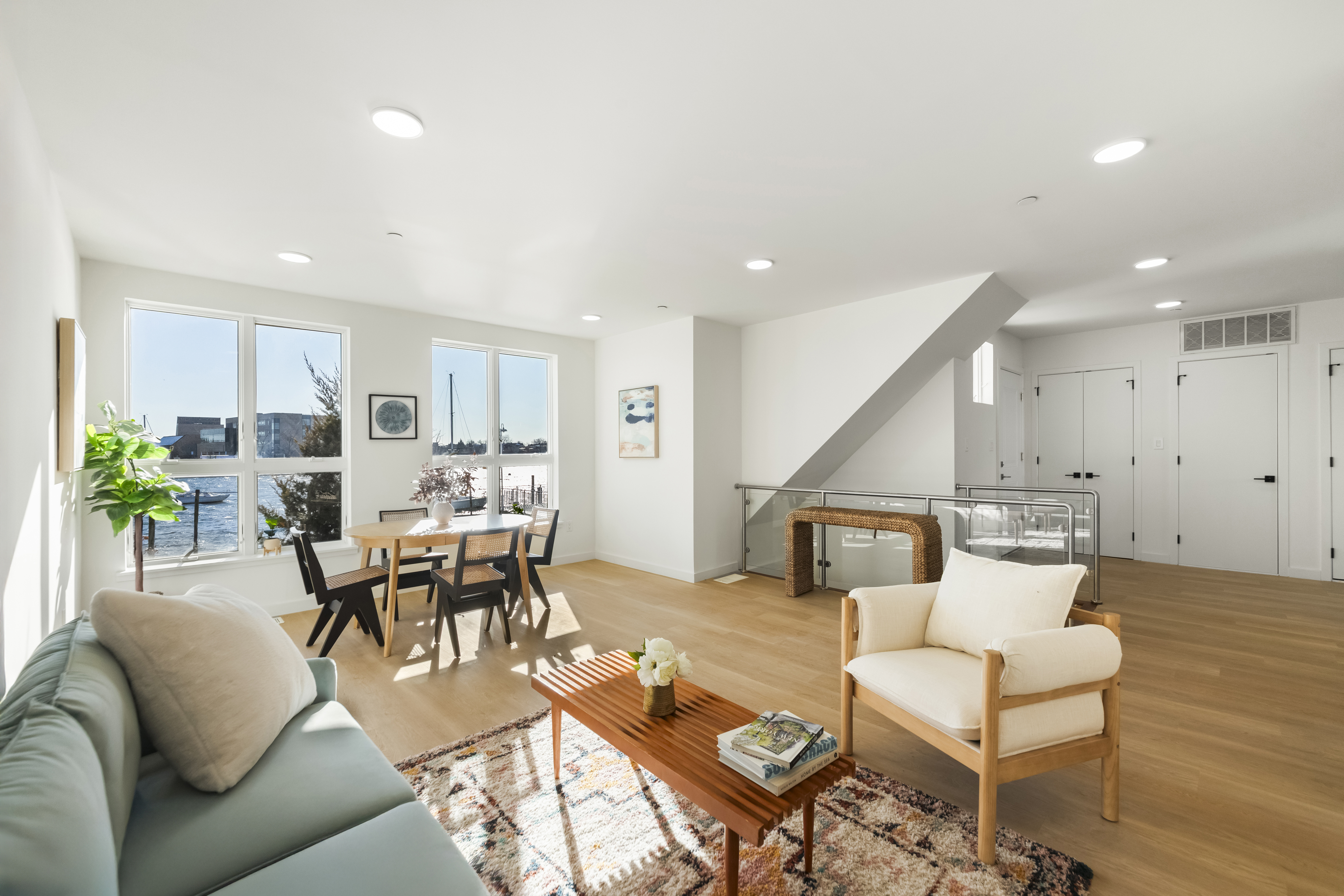 a living room with furniture kitchen view and a wooden floor