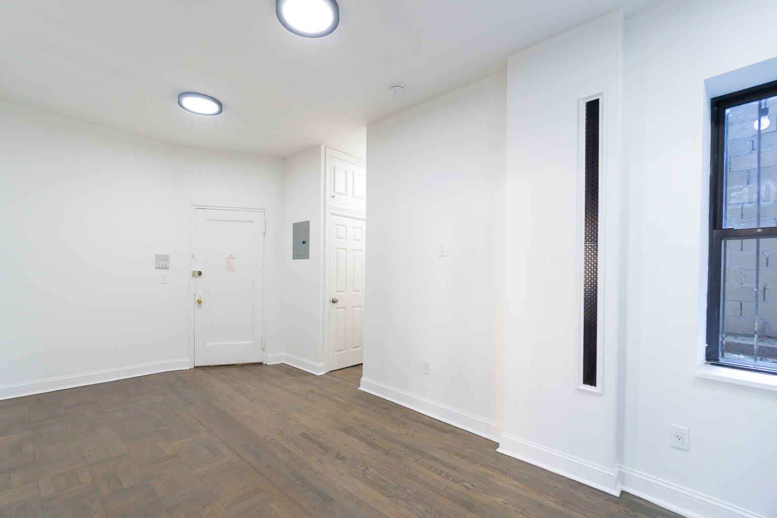 51 East 2nd Street, Unit 2 Manhattan, NY 10003 - Photo 8 of 18 an empty room with wooden floor and window