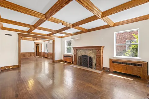a view of empty room with fireplace and wooden floor