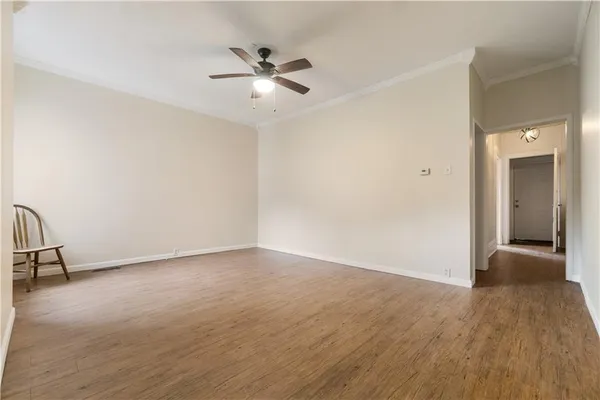 a view of an empty room with wooden floor