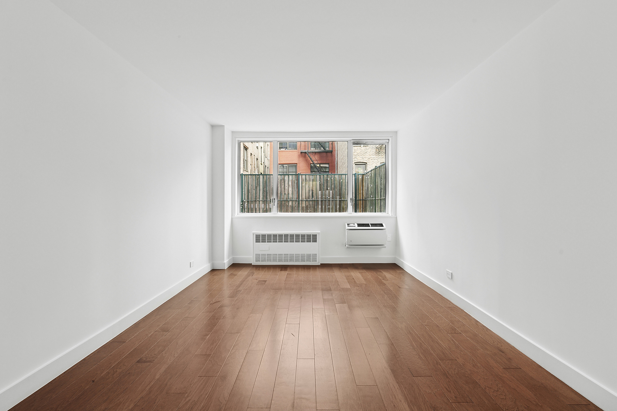 333 East 14th Street, Unit 2C Manhattan, NY 10003 - Photo 7 of 12 a view of a room with wooden floor and window