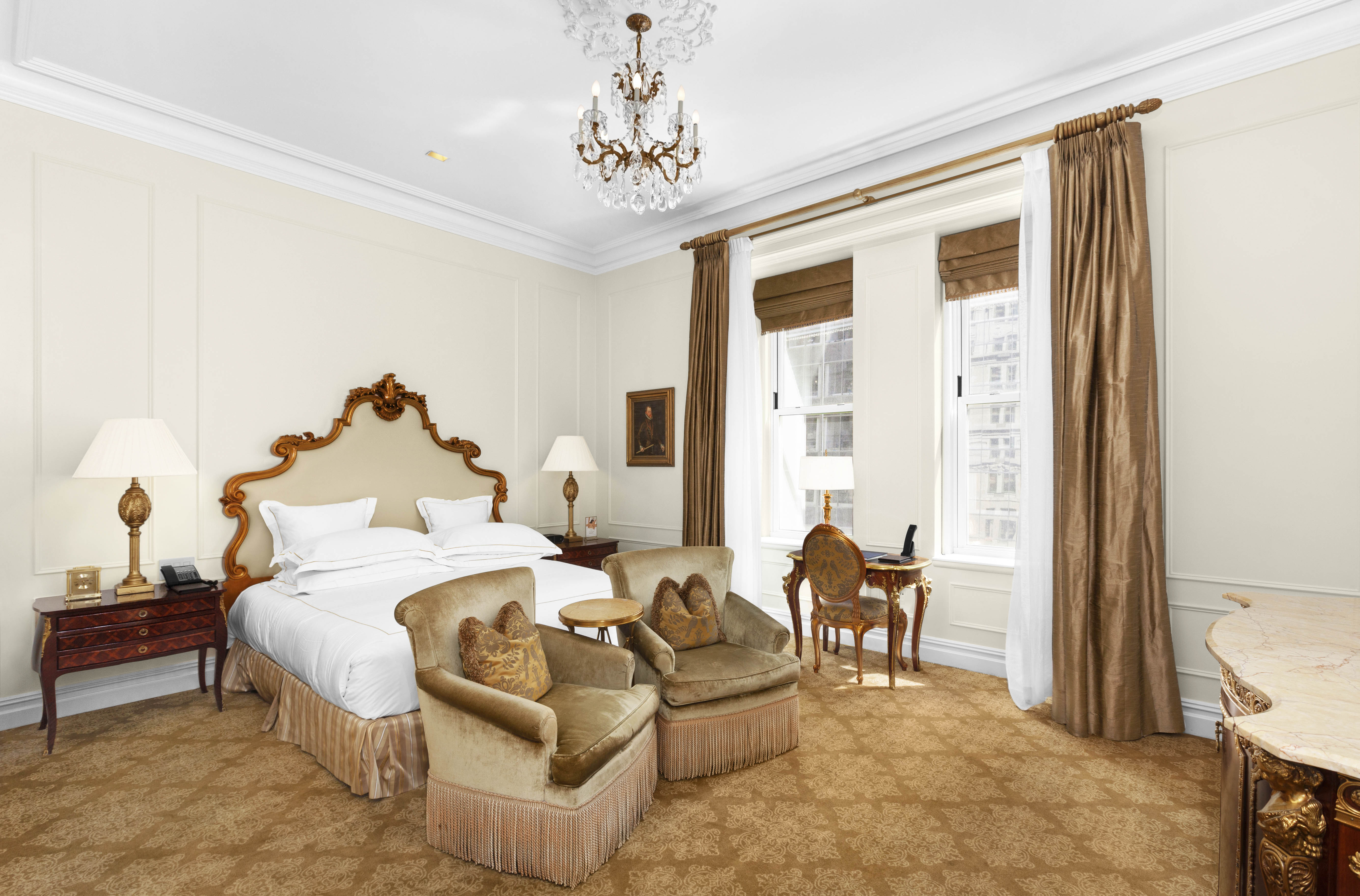 a spacious bedroom with a bed and a chandelier