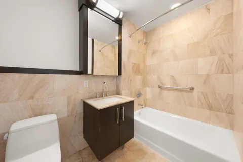 a bathroom with a sink mirror toilet and bathtub