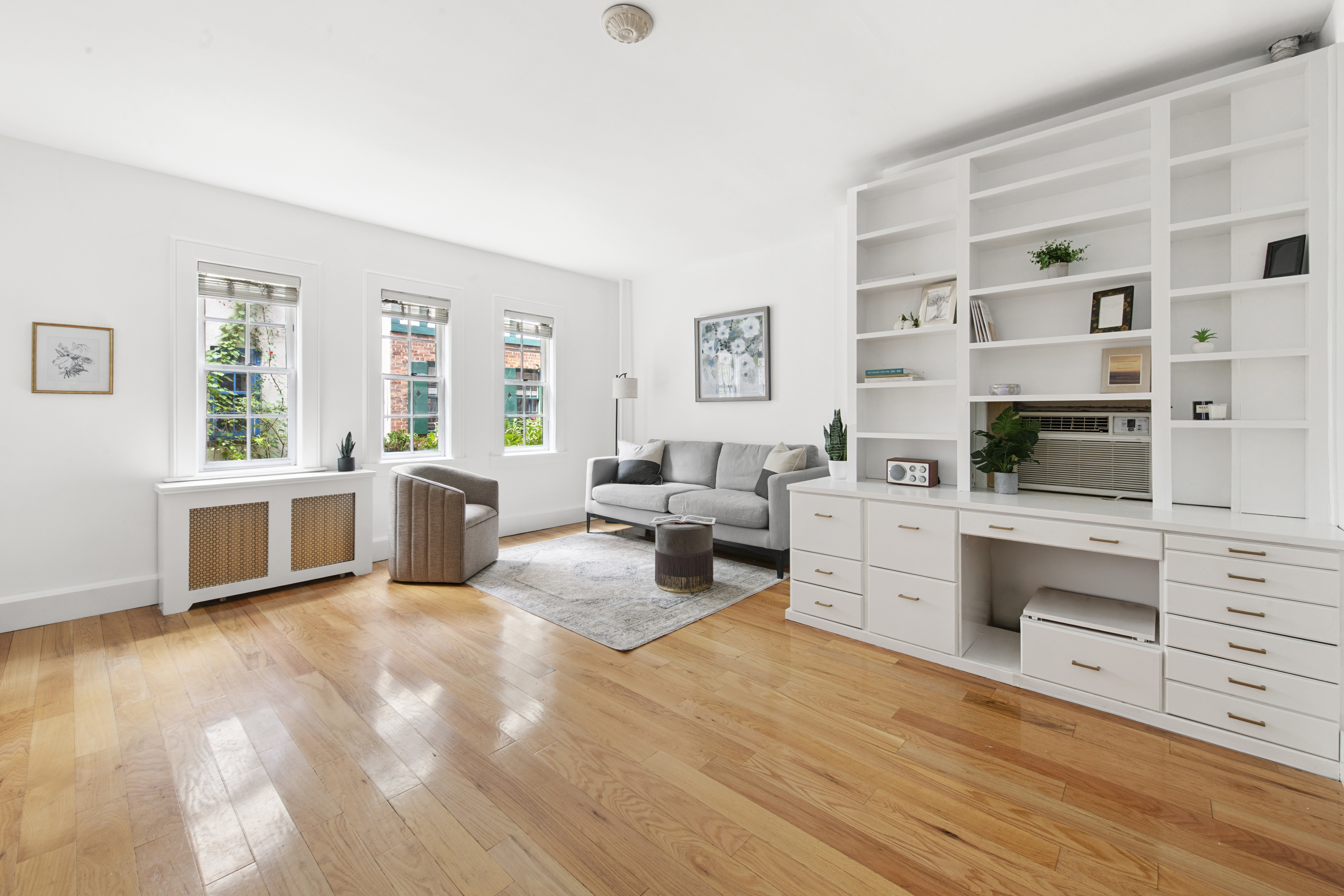 10 Pomander Walk, Unit 1 Manhattan, NY 10025 - Photo 2 of 13 a large white room with stainless steel appliances kitchen island granite countertop a stove a sink a refrigerator and white cabinets with wooden floor