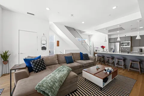 a living room with furniture and wooden floor