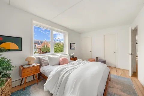 a bedroom with a bed and a painting on the wall