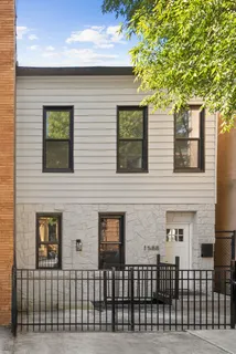 a front view of a house with a tree