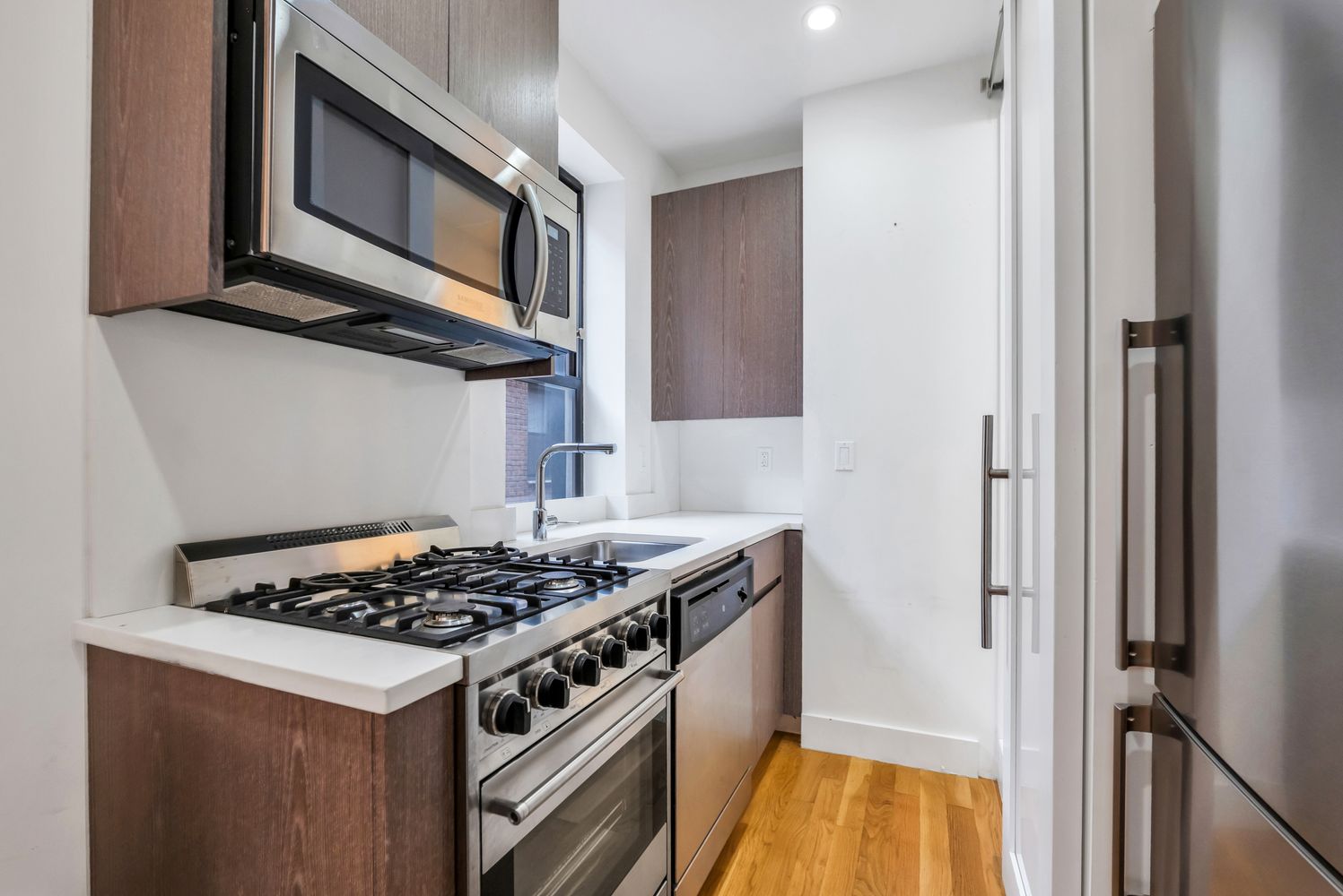 223 West 10th Street, Unit 2C Manhattan, NY 10014 - Photo 6 of 11 a kitchen with stainless steel appliances granite countertop a stove and a microwave