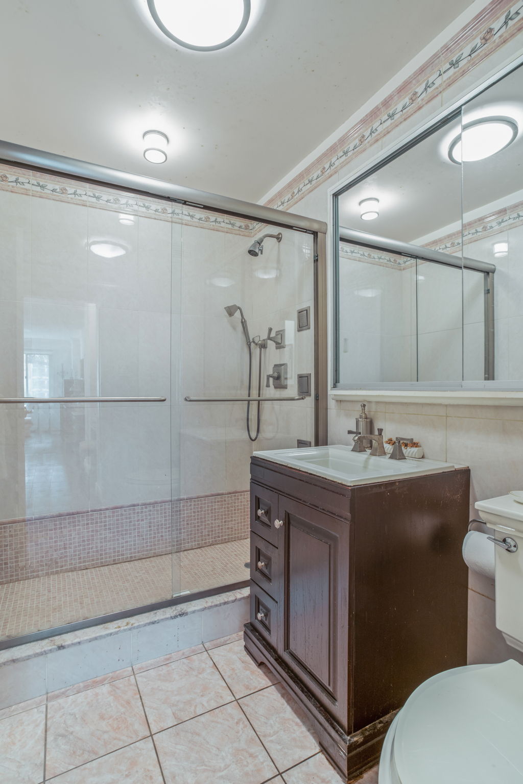 30 East 65th Street, Unit 3B Manhattan, NY 10065 - Photo 7 of 12 a bathroom with a double vanity sink mirror and toilet