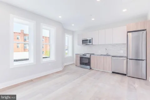 a kitchen with stainless steel appliances granite countertop a refrigerator sink and cabinets