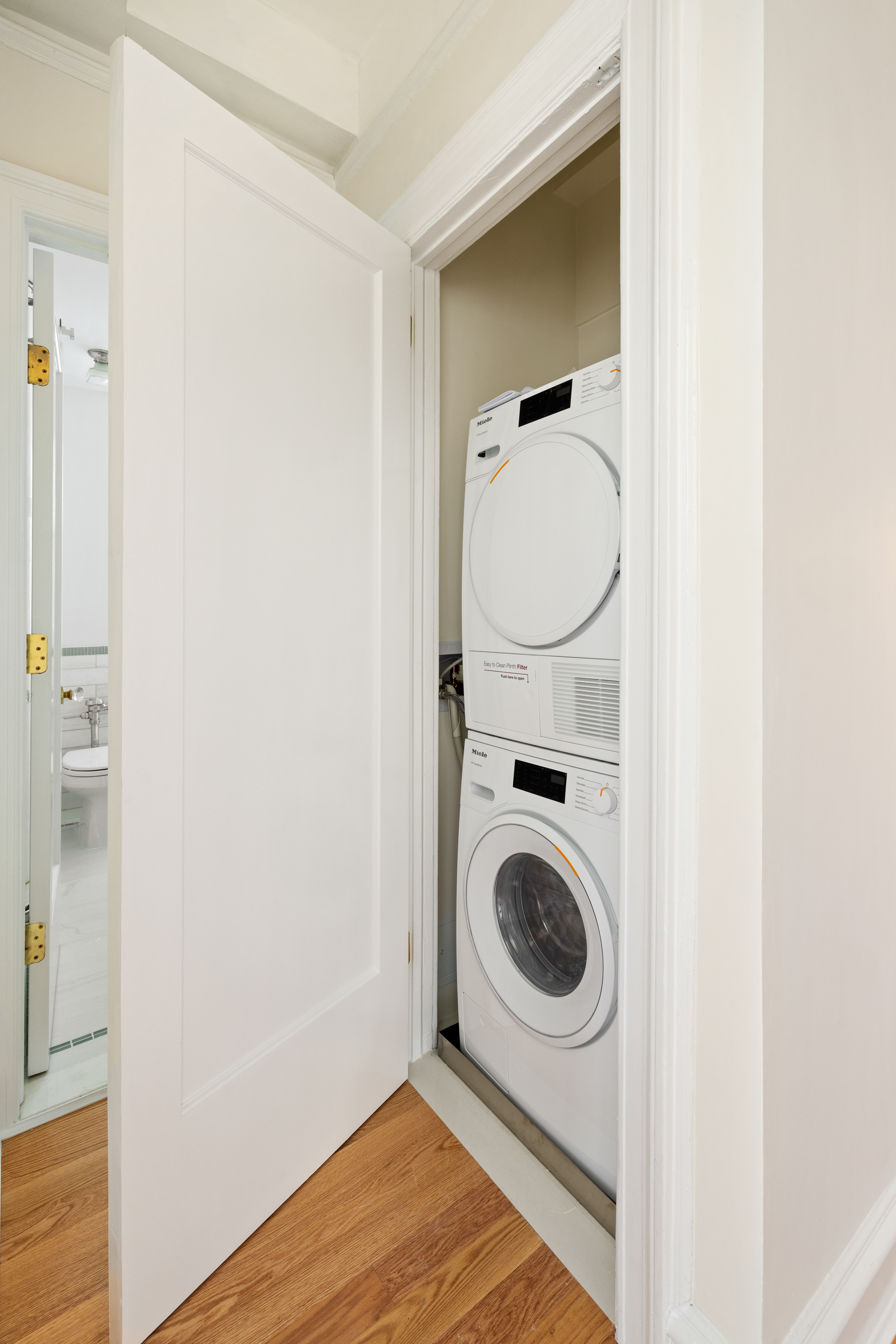 240 West 98th Street, Unit 7D Manhattan, NY 10025 - Photo 8 of 14 a utility room with wooden floor washer and dryer