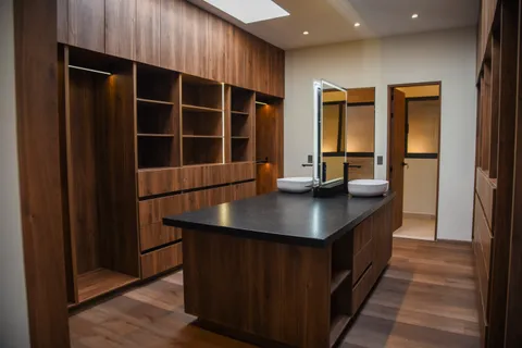 a view of an empty room with wooden floor and closet
