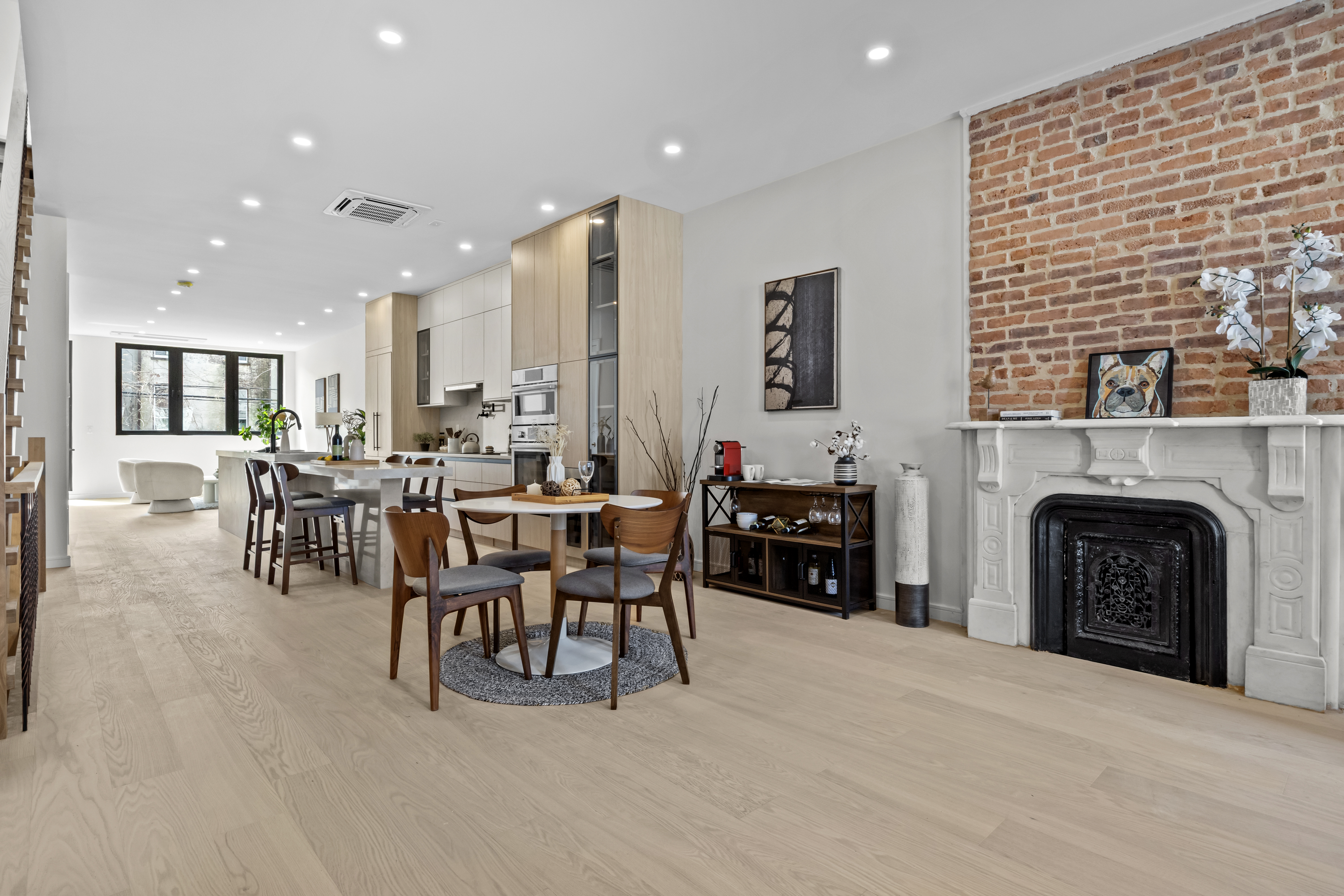 a living room with furniture a fireplace and a kitchen view