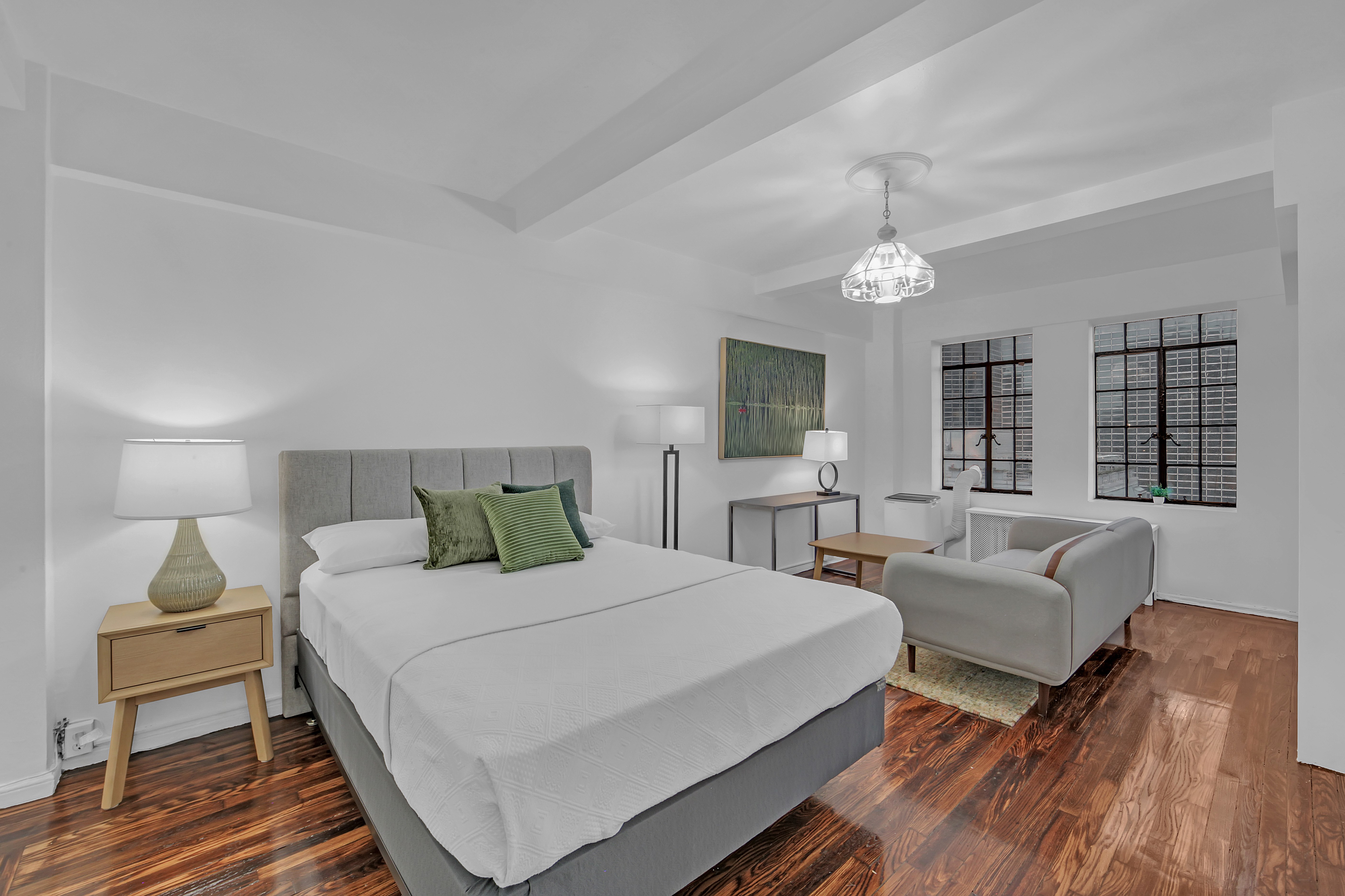 45 Tudor City Place, Unit 1902 Manhattan, NY 10017 - Photo 2 of 19 a bedroom with a bed and wooden floor