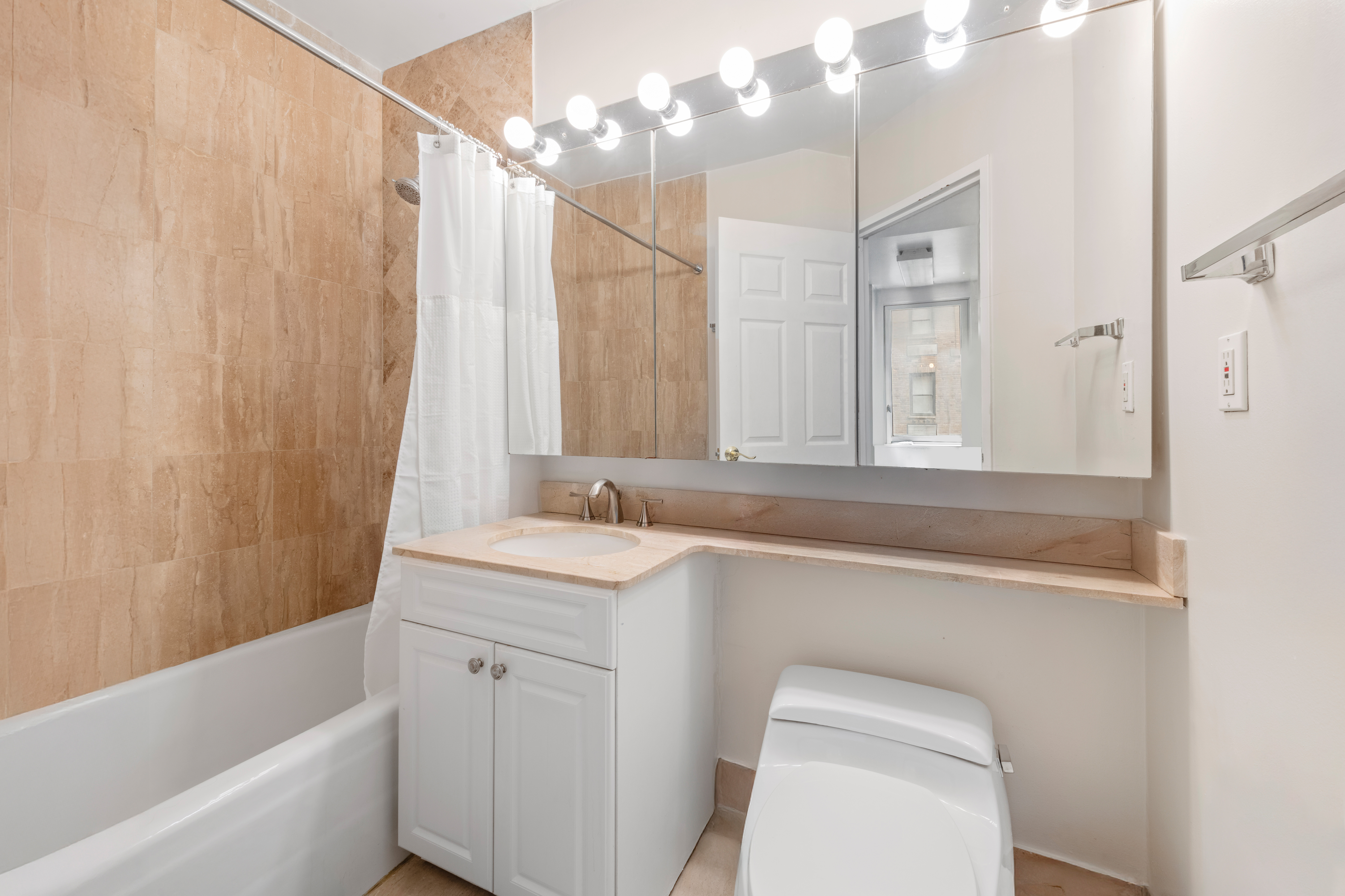 145 East 48th Street, Unit 12B Manhattan, NY 10017 - Photo 6 of 7 a bathroom with a sink a toilet and a bathtub