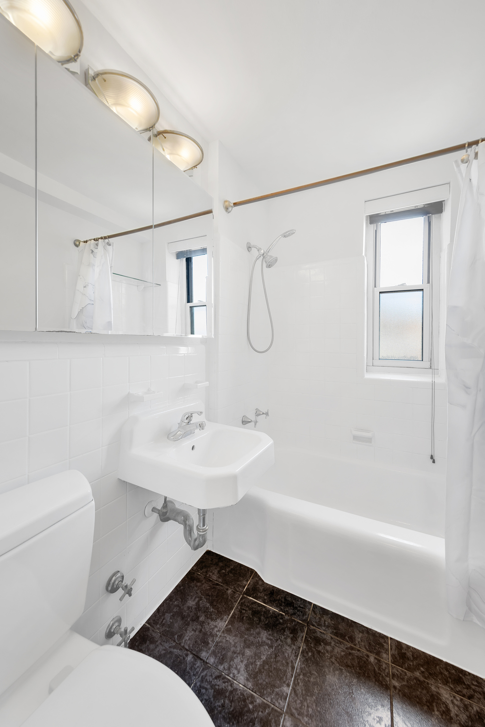 530 Grand Street, Unit E8C Manhattan, NY 10002 - Photo 6 of 15 a bathroom with a sink toilet a mirror and shower