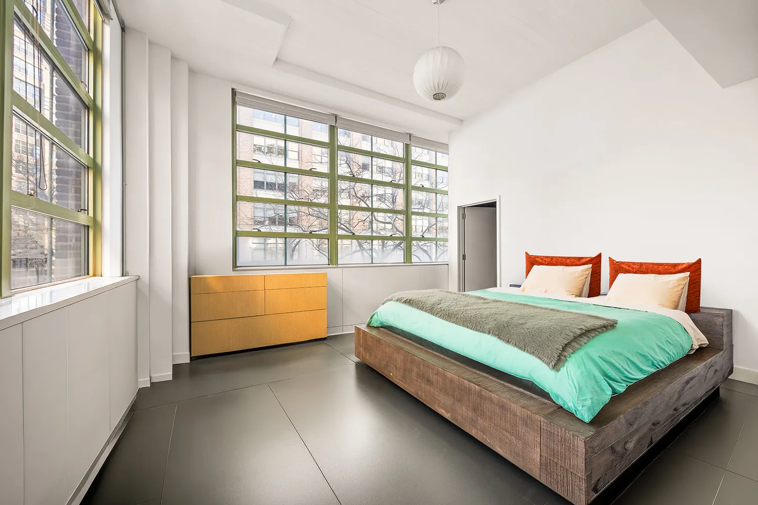 a bedroom with a bed and a large window