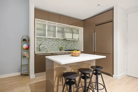 a view of kitchen island with furniture and refrigerator