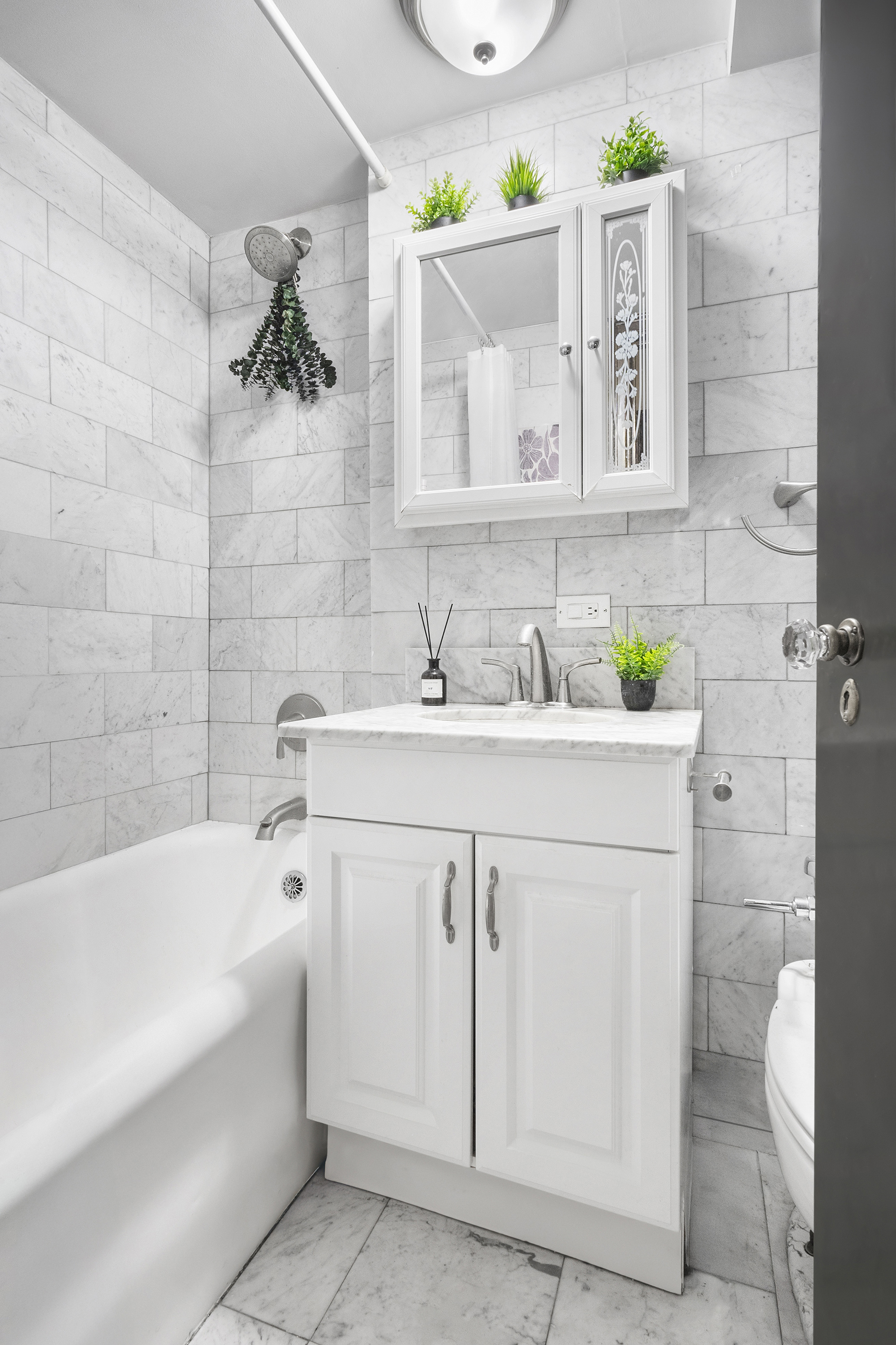 25 Tudor City Place, Unit 922 Manhattan, NY 10017 - Photo 3 of 9 a bathroom with a sink vanity and bathtub