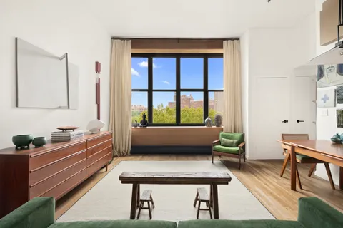 a living room with a couch and a potted plant