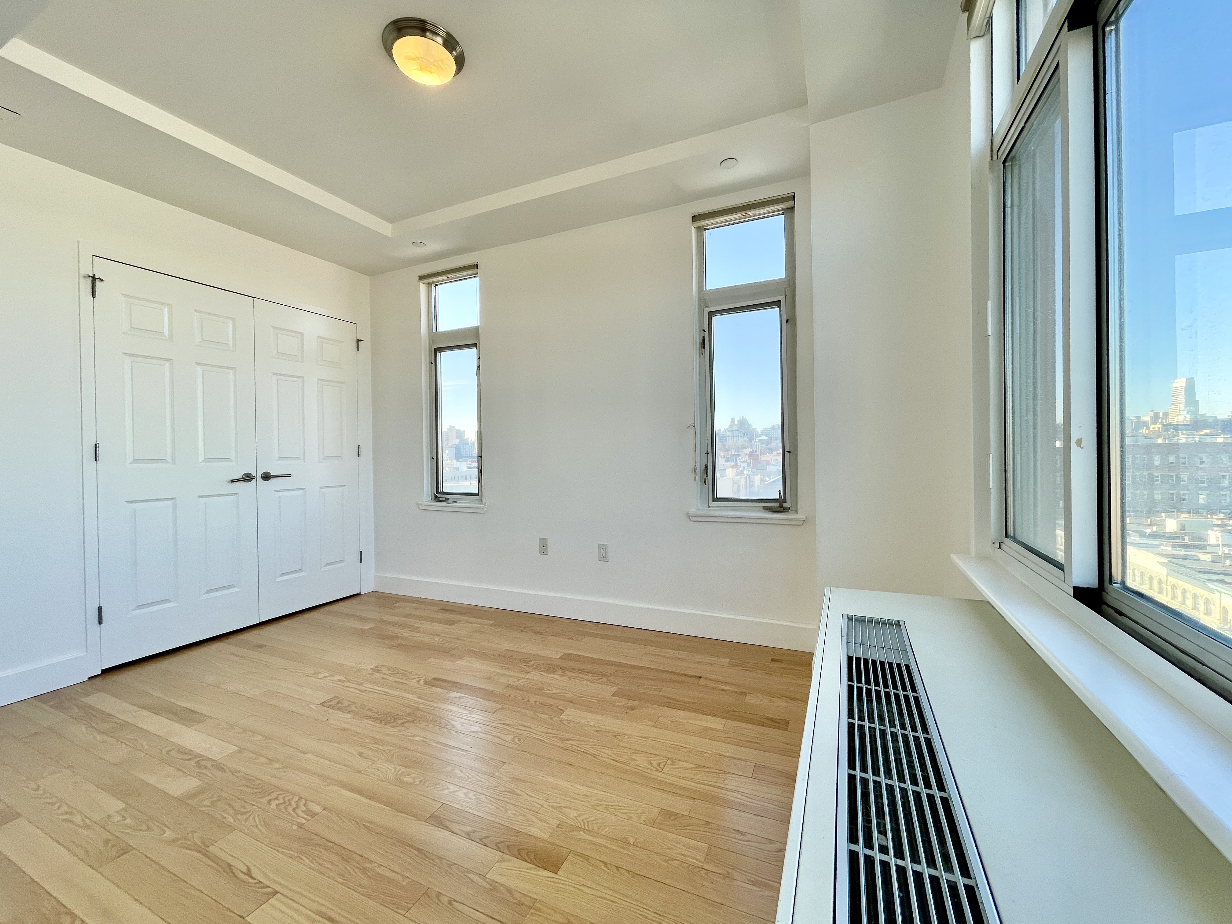 106 West 116th Street, Unit 12A Manhattan, NY 10026 - Photo 6 of 13 a view of a room with wooden floor and window