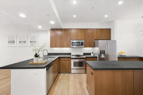 a kitchen with stainless steel appliances granite countertop a sink stove and refrigerator