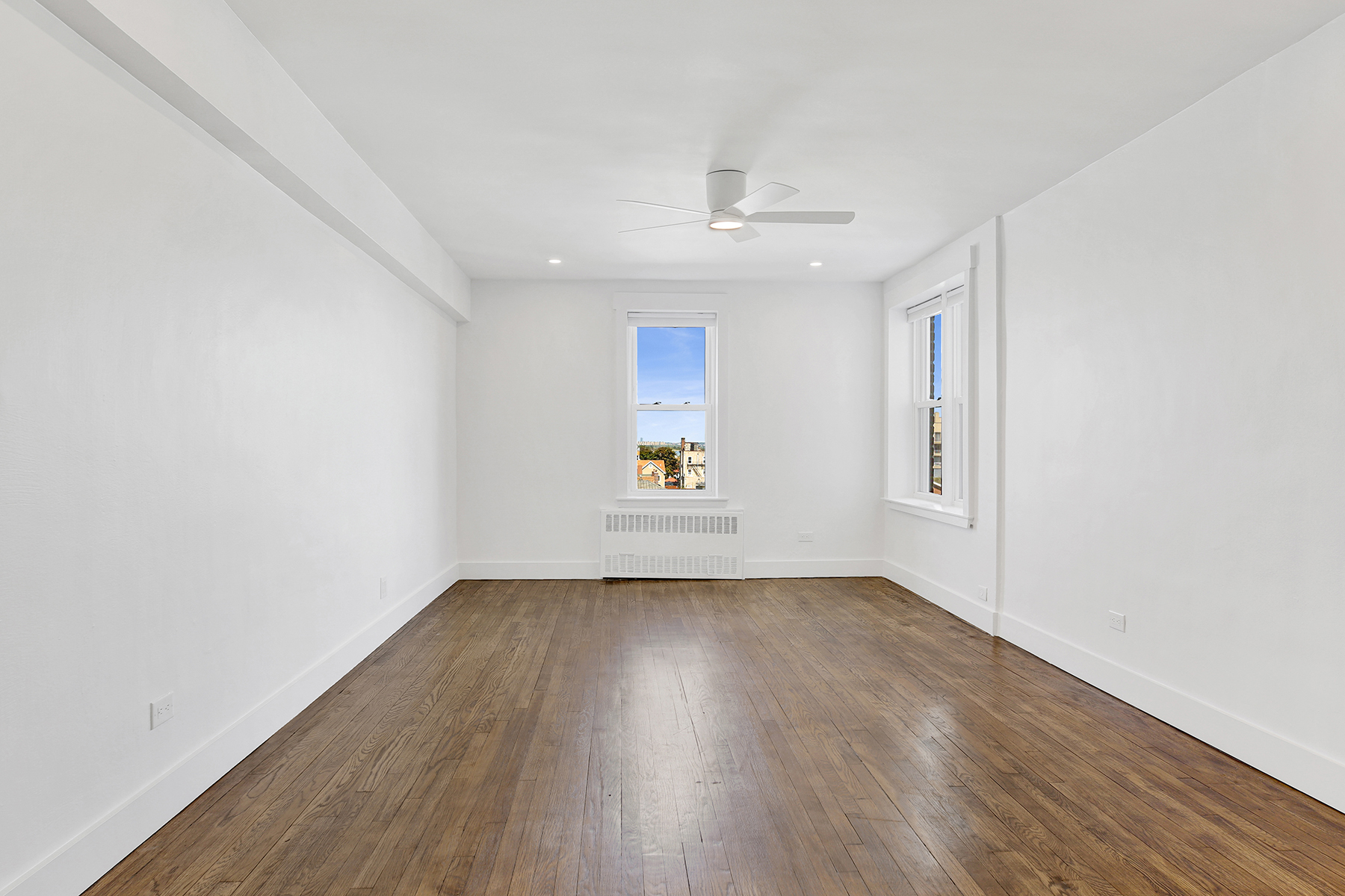125 Beach 124th Street, Unit 5K Queens, NY 11694 - Photo 9 of 21 an empty room with wooden floor and windows
