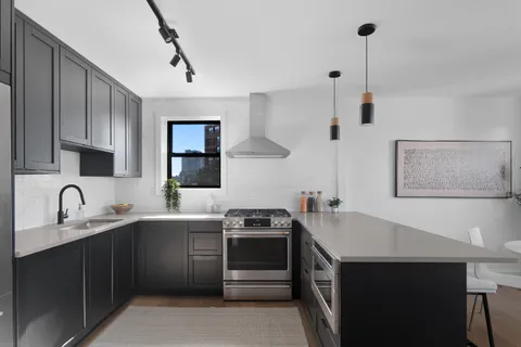 a kitchen with a sink stove and cabinets